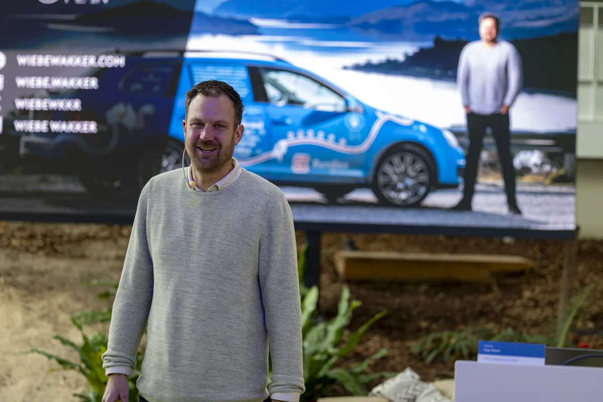 Spreker over Samenwerken Spreker Samenwerken Wiebe Wakker op het podium van een evenement waar hij een lezing geeft over samenwerken.