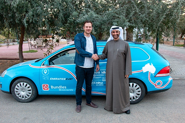 Voorbeeld van samenwerken met sjeik in de Emiraten Wiebe Wakker schudt de hand met een sjeik in de Emiraten. Beiden staan voor de Blue Bandit elektrische auto waarmee Wakker een wereldreis maakte van Nederland naar Australie.